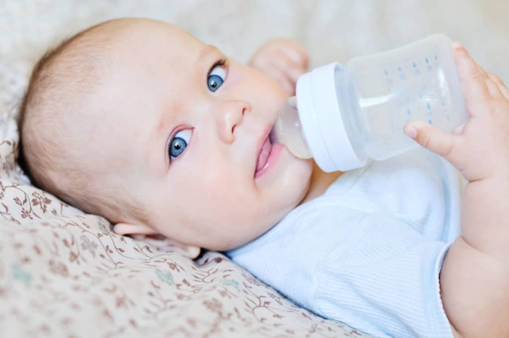 Baby holding bottle and drinking without help.