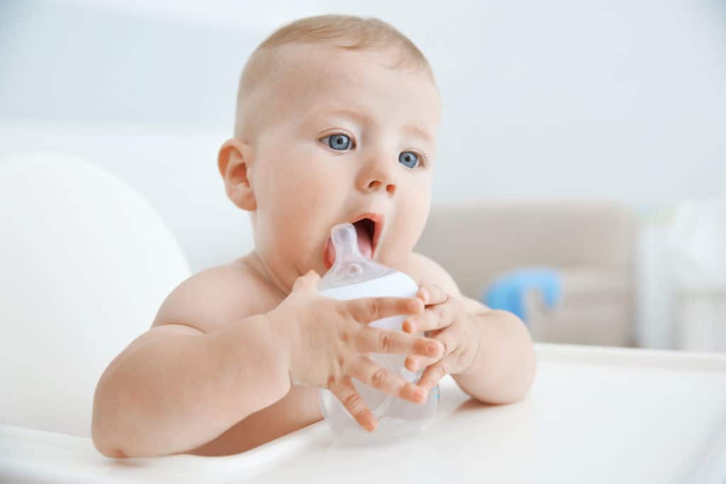 when should babies hold their own bottle