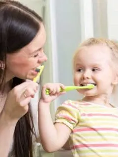 mom and toddler brushing teeth