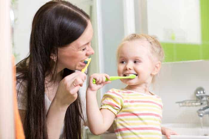 Mom and toddler brushing teeth