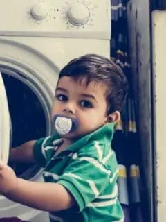toddler opening laundry machine door