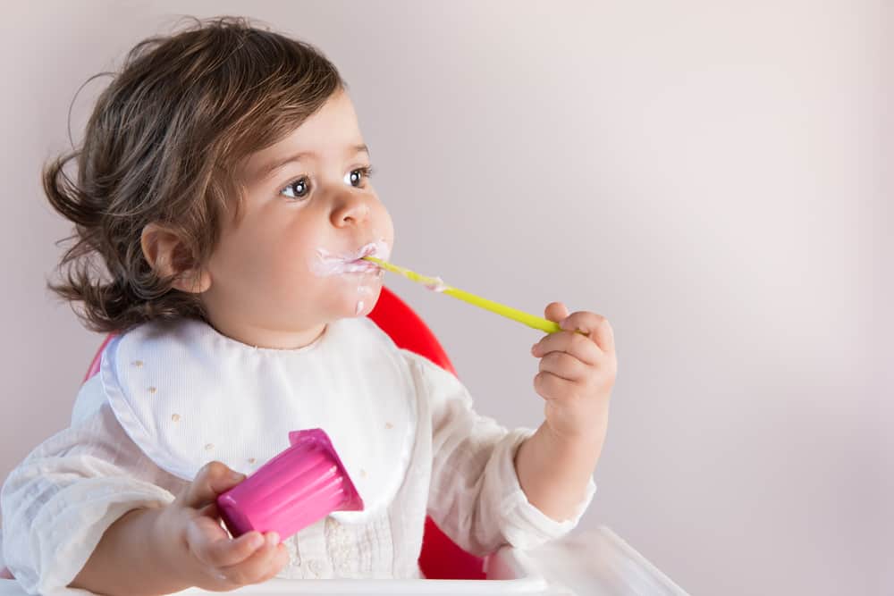 Toddler eating yogurt