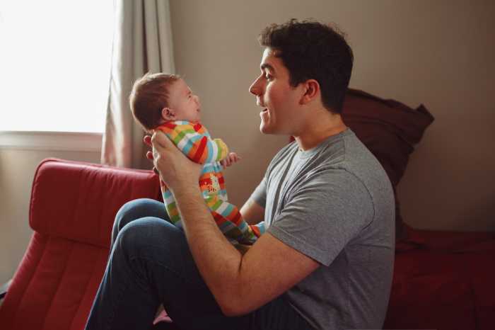 dad holding baby and talking to them