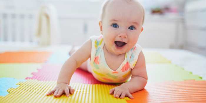 Baby laying on stomach and smiling