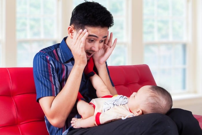 Dad playing peek a boo with baby