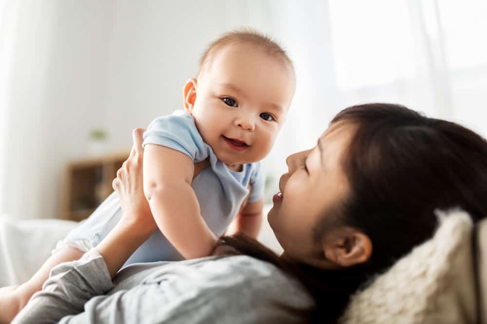 mom holding baby and smiling