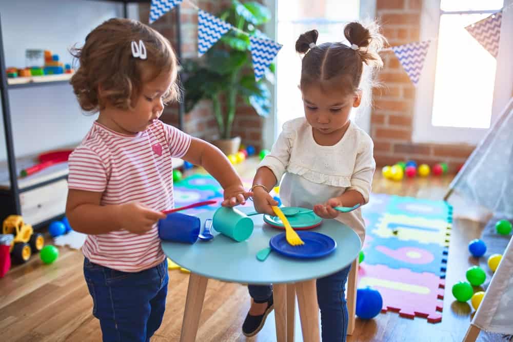 toddlers playing together at table