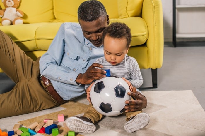 toddler and dad looking at ball