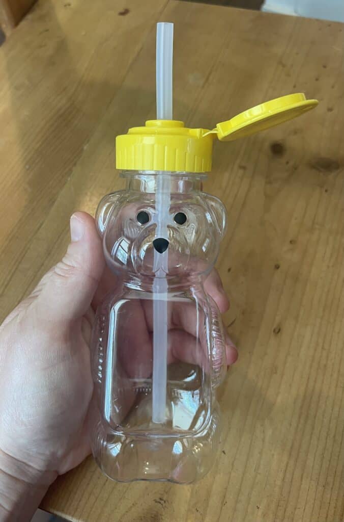 hand holding a honey bear cup