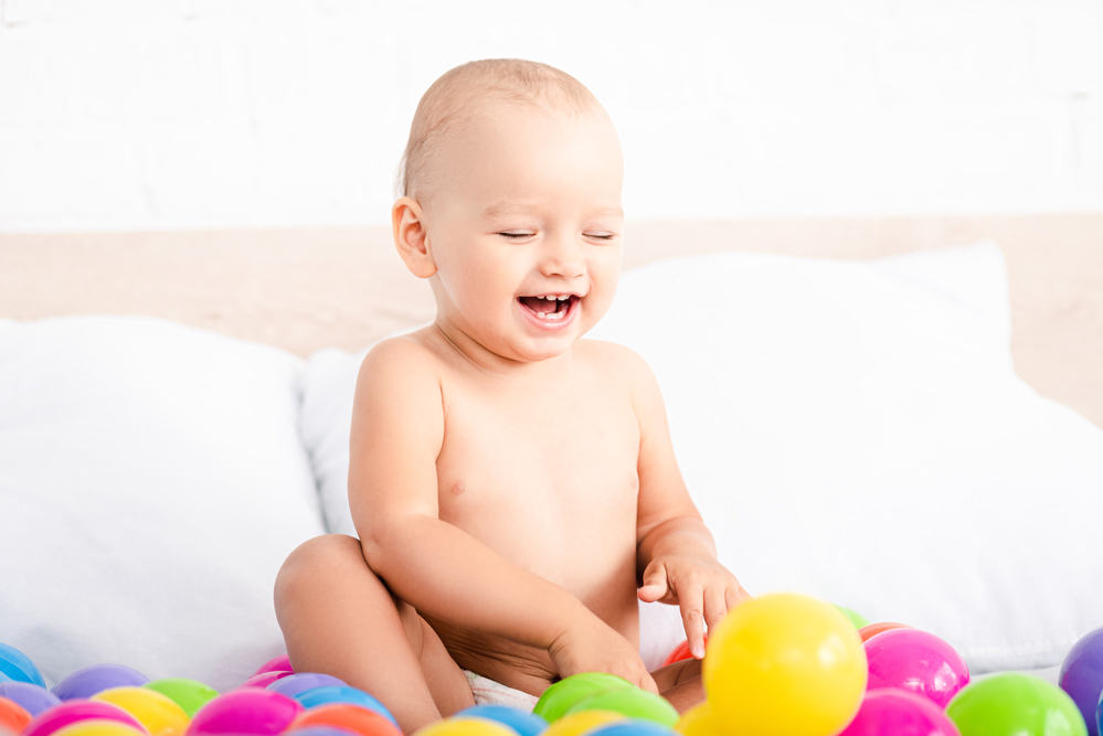 toddler playing in ball pit