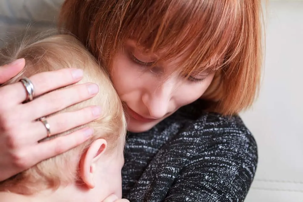 Mother cuddles her son