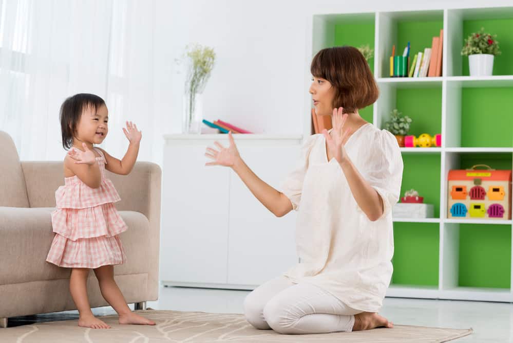 Chinese mother and daughter playing clapping game 