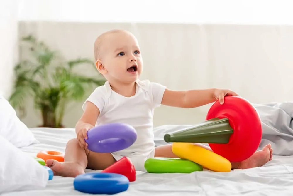 baby playing with a ring stacker toy