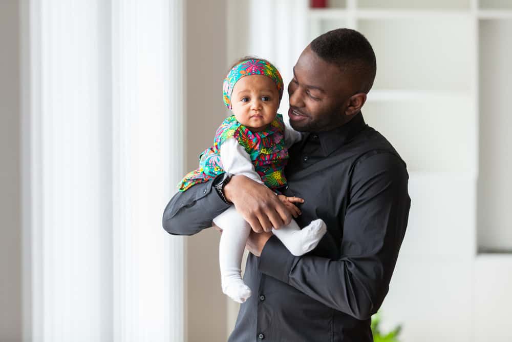 Young african american father holding with her baby girl