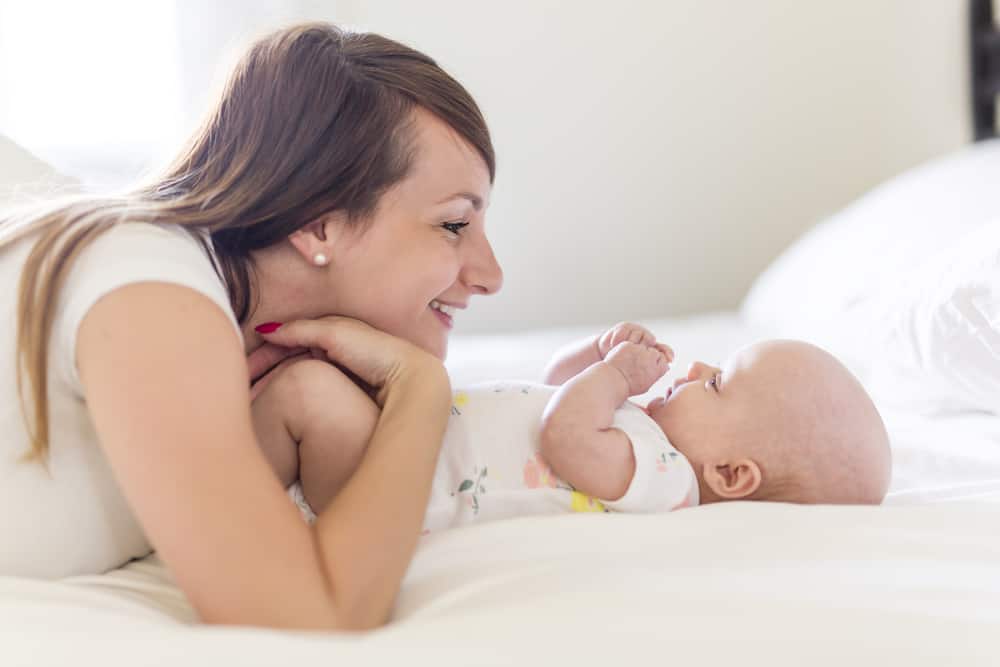 A Portrait of mother with her 3 month old baby in bedroom