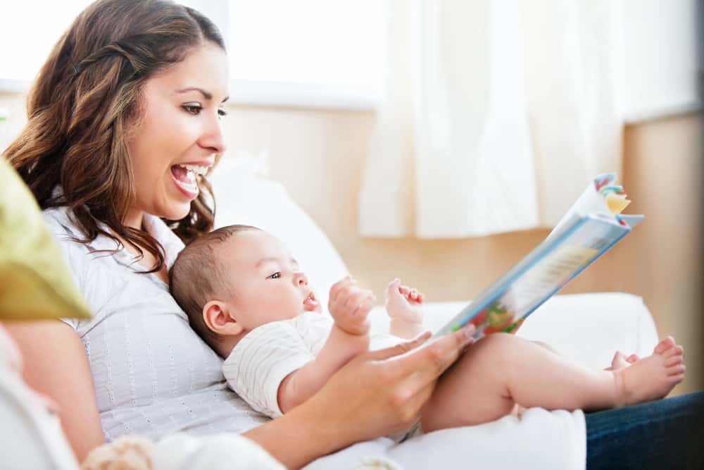 mom looking at books with baby