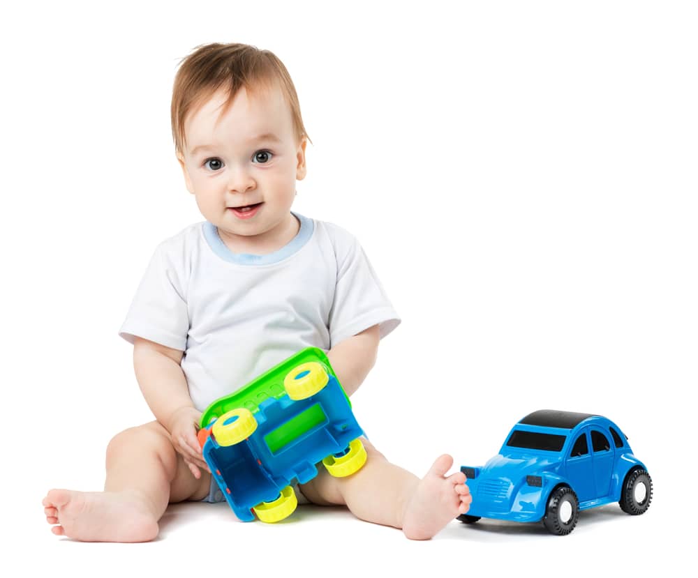 baby playing with green toy car