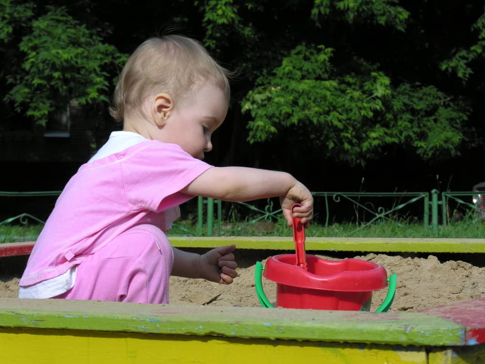 toddler digging in sandbox