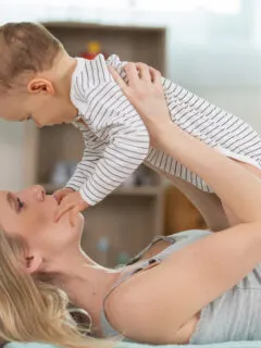 mom holding baby above her