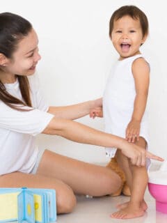 mom pointing at potty with toddler