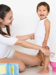 mom pointing at potty with toddler